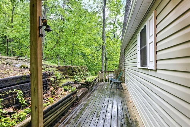 wooden deck featuring a forest view