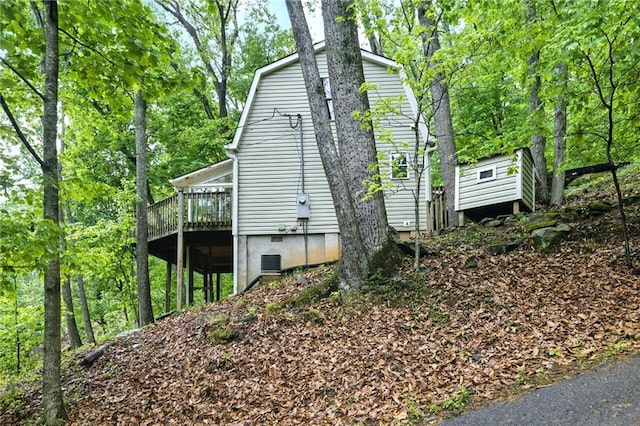 view of home's exterior featuring a wooden deck and a gambrel roof