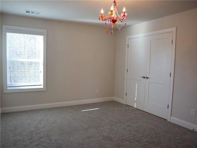 unfurnished bedroom featuring a closet, carpet flooring, visible vents, and baseboards