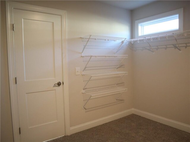 carpeted spare room featuring a chandelier, visible vents, and baseboards