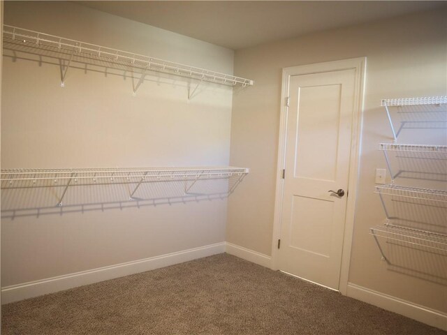 unfurnished bedroom with a notable chandelier, carpet flooring, visible vents, baseboards, and a closet