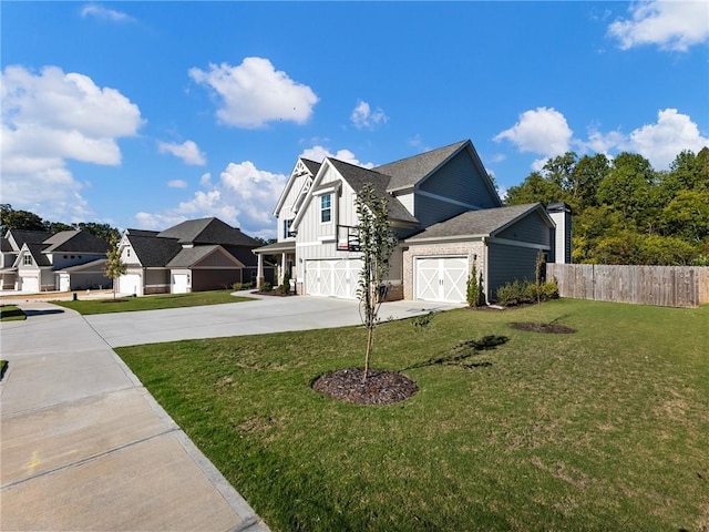 view of front facade with fence, concrete driveway, a residential view, a front lawn, and board and batten siding