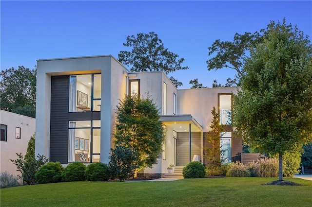 contemporary house featuring a front yard and stucco siding