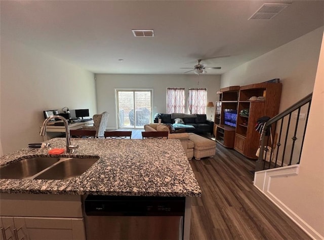 kitchen with ceiling fan, dark wood-type flooring, dishwasher, stone counters, and sink