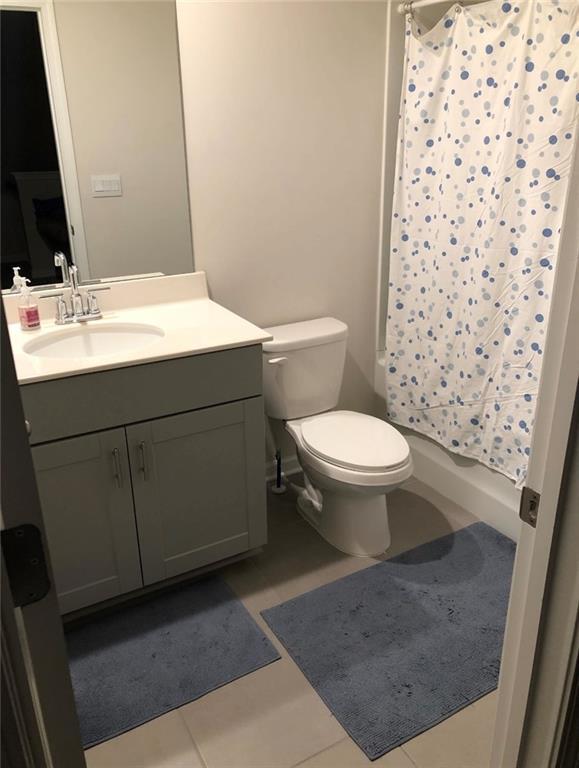 bathroom featuring toilet, vanity, and tile patterned flooring