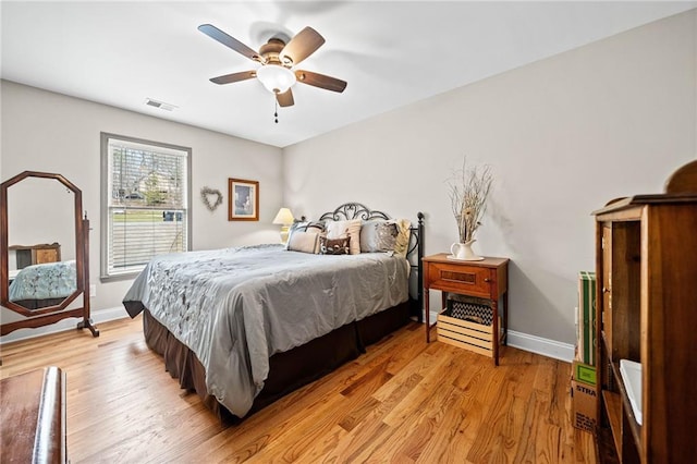 bedroom featuring baseboards, light wood-style flooring, and ceiling fan