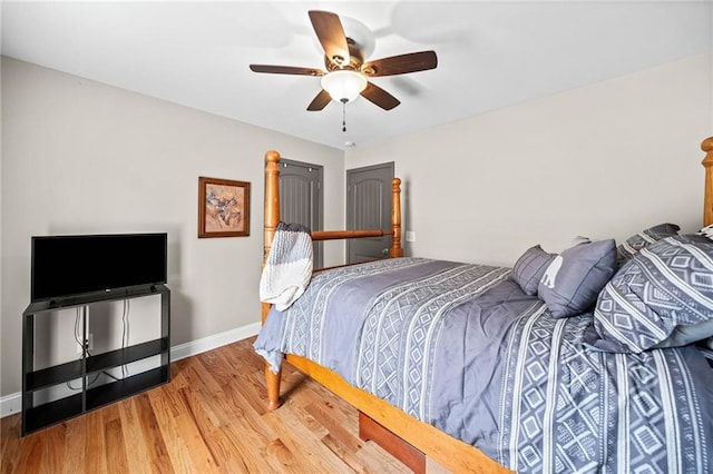 bedroom featuring wood finished floors, baseboards, and ceiling fan