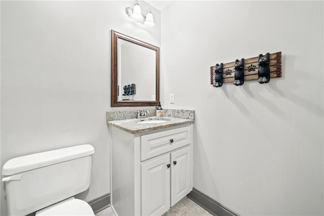 half bath with baseboards, toilet, and vanity