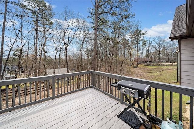 wooden deck with a yard and view of scattered trees
