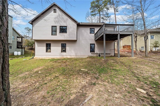 back of house featuring a deck and a lawn