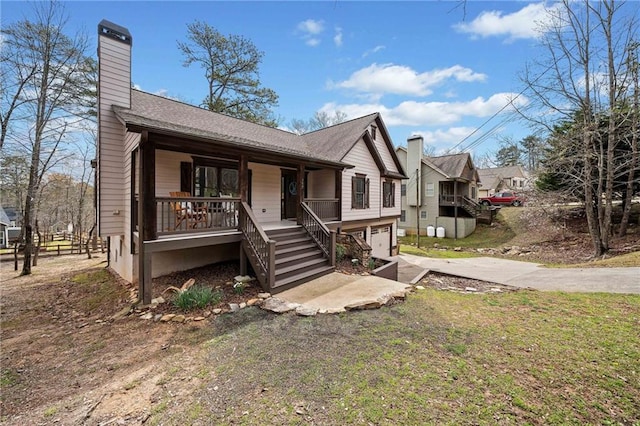 single story home with covered porch, concrete driveway, a garage, a chimney, and stairway