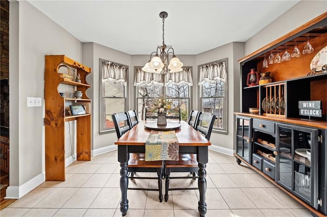 dining room featuring a chandelier, baseboards, and light tile patterned floors
