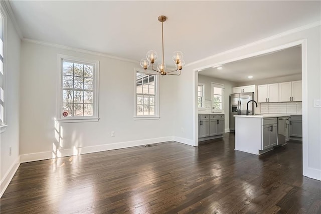 interior space with an inviting chandelier, sink, dark wood-type flooring, and ornamental molding