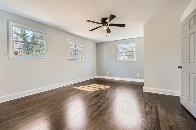 spare room with dark hardwood / wood-style flooring, ceiling fan, and a healthy amount of sunlight