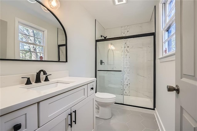 bathroom featuring vanity, tile patterned flooring, toilet, and walk in shower