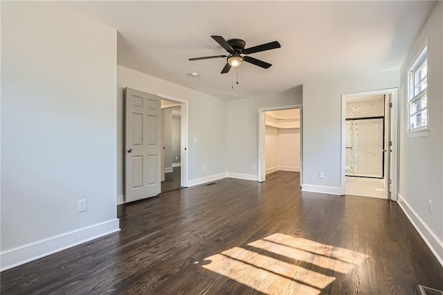 unfurnished bedroom featuring ceiling fan, a walk in closet, dark hardwood / wood-style floors, and a closet