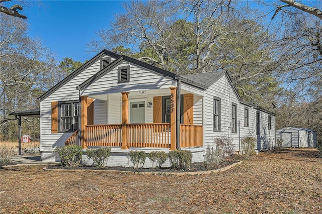 bungalow featuring a storage unit and a porch