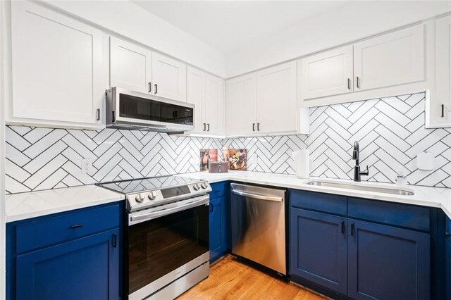 kitchen with sink, stainless steel appliances, and blue cabinetry