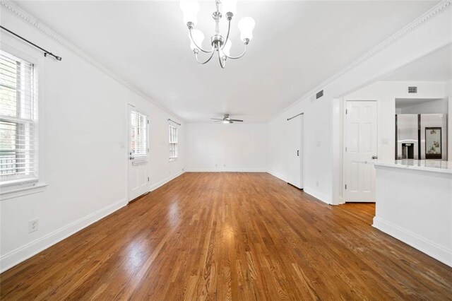 dining space featuring wood-type flooring, ceiling fan with notable chandelier, and crown molding