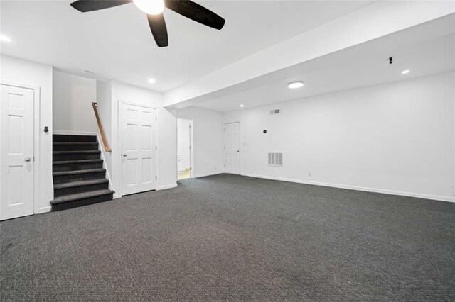 interior space featuring ceiling fan and dark carpet