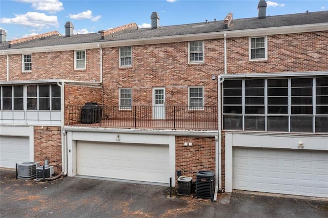 back of property with a garage and central air condition unit