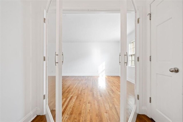 empty room featuring hardwood / wood-style flooring, ornamental molding, and french doors