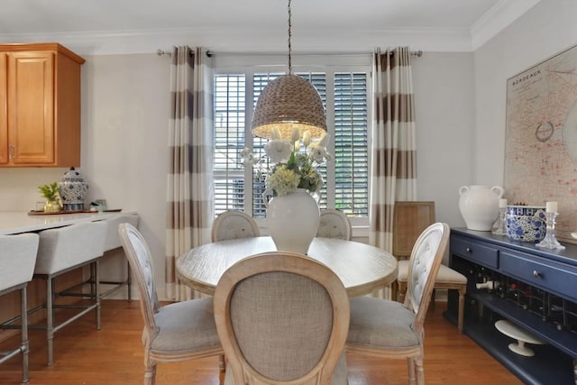 dining room with light wood finished floors, a wealth of natural light, and crown molding