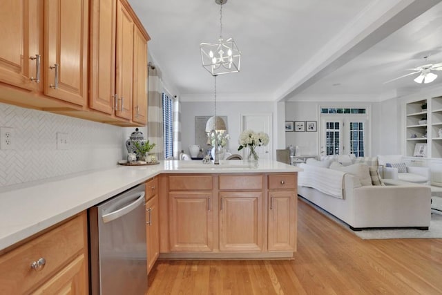 kitchen with a peninsula, open floor plan, stainless steel dishwasher, light wood finished floors, and crown molding