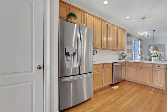 kitchen featuring a chandelier, light brown cabinets, light wood-style flooring, light countertops, and appliances with stainless steel finishes