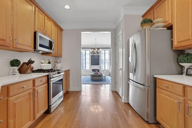 kitchen featuring stainless steel appliances, tasteful backsplash, light wood-type flooring, and crown molding