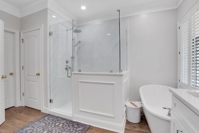 full bathroom with a marble finish shower, crown molding, vanity, a freestanding tub, and wood finish floors