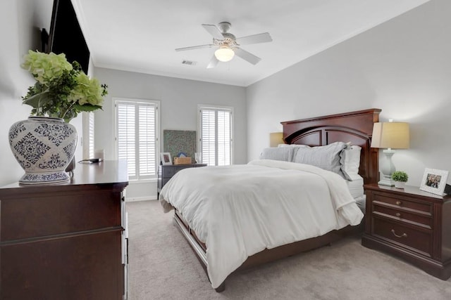 bedroom with ornamental molding, light colored carpet, ceiling fan, and baseboards