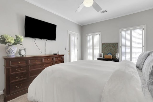 bedroom with light carpet, a ceiling fan, visible vents, and crown molding