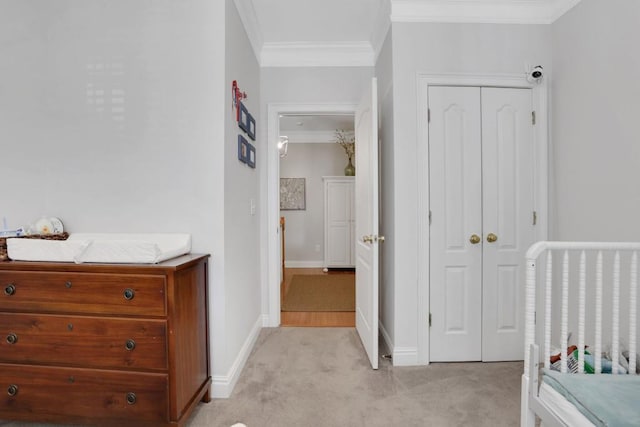 bedroom featuring baseboards, ornamental molding, a closet, and light colored carpet