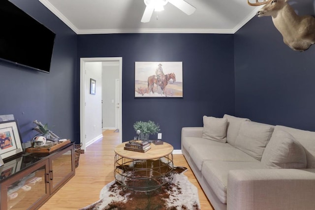 living area featuring ornamental molding, wood finished floors, a ceiling fan, and baseboards