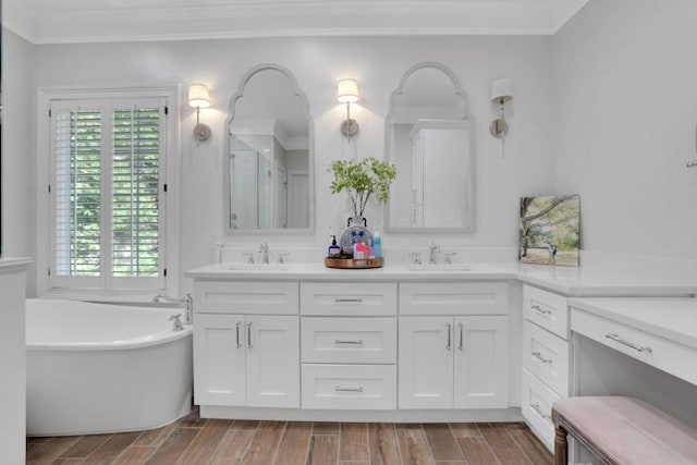 bathroom with wood tiled floor, a freestanding bath, ornamental molding, and a sink