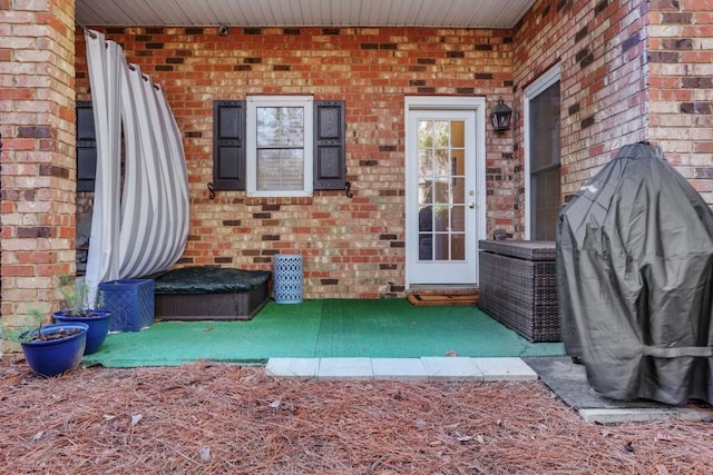 view of exterior entry featuring brick siding