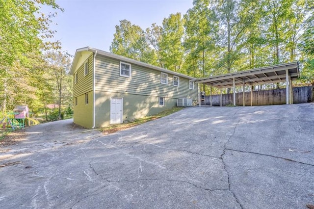 111 Sylvan Dr, Calhoun, GA 30701 - view of side of property with asphalt driveway, central air condition unit, and a carport