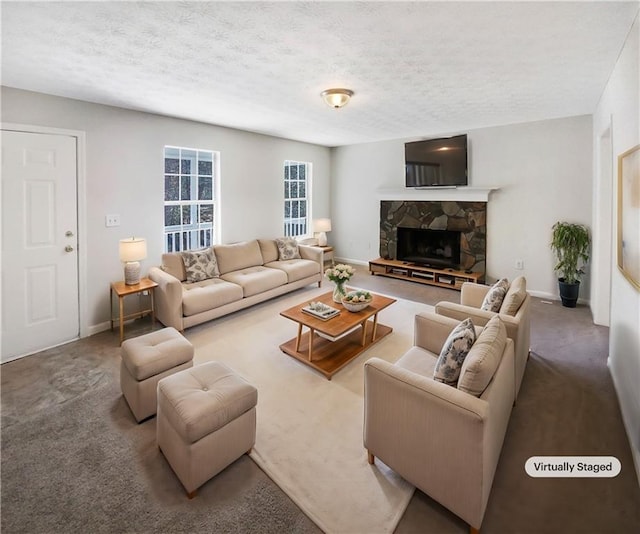 living area with a textured ceiling, a stone fireplace, and carpet flooring