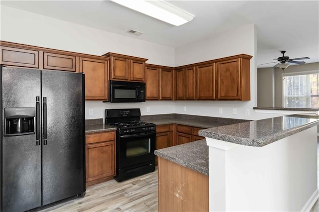 kitchen with ceiling fan, kitchen peninsula, light wood-type flooring, and black appliances