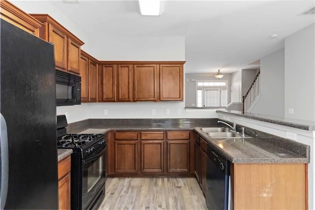 kitchen with sink, light hardwood / wood-style flooring, black appliances, and kitchen peninsula