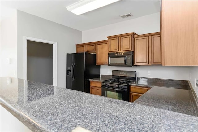 kitchen with kitchen peninsula and black appliances