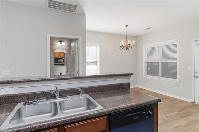 kitchen with sink, hanging light fixtures, light wood-type flooring, a notable chandelier, and black appliances