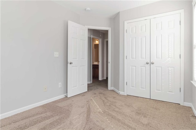 unfurnished bedroom featuring a closet and light carpet