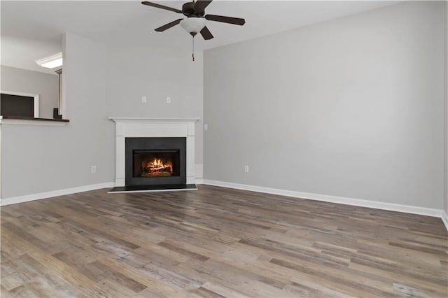 unfurnished living room featuring ceiling fan and wood-type flooring