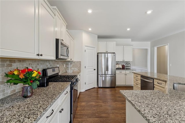 kitchen with stainless steel appliances, light stone countertops, dark wood-style flooring, and white cabinetry