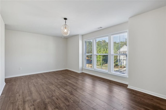 unfurnished room featuring visible vents, baseboards, and dark wood-style floors