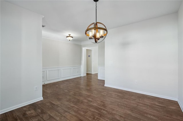 empty room featuring baseboards, ornamental molding, a chandelier, dark wood-style floors, and a decorative wall