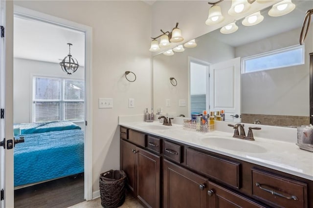 ensuite bathroom with a sink, double vanity, an inviting chandelier, and ensuite bath