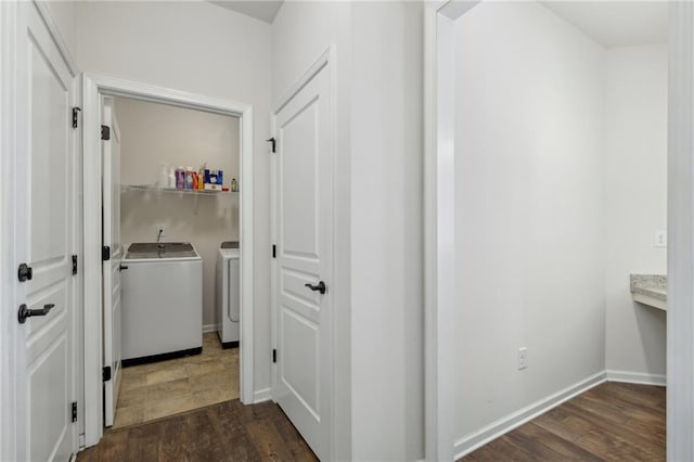 laundry area with laundry area, washing machine and clothes dryer, baseboards, and dark wood-style floors